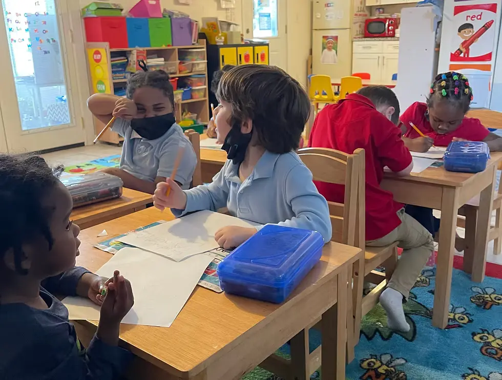 Happy kids gathered around a table, learning and playing together at Keziah's Early Learning Academy